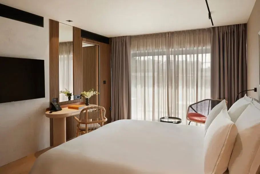 Suite-Interieur mit Doppelbett, eleganter Beleuchtung und gemütlicher Sitzecke.
