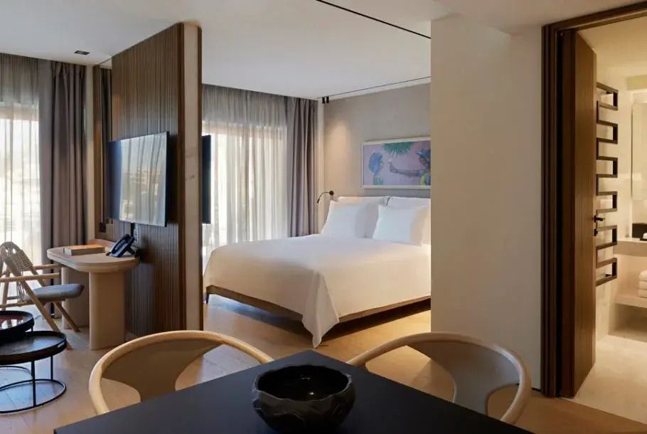 Moderne Suite mit Doppelbett und eleganter Trennwand im Dusit Suites Athens.