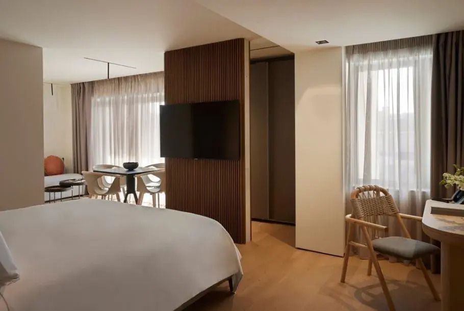 Helles Zimmer mit Doppelbett, großem Fenster und Fernseher in der Kassiope Suite.