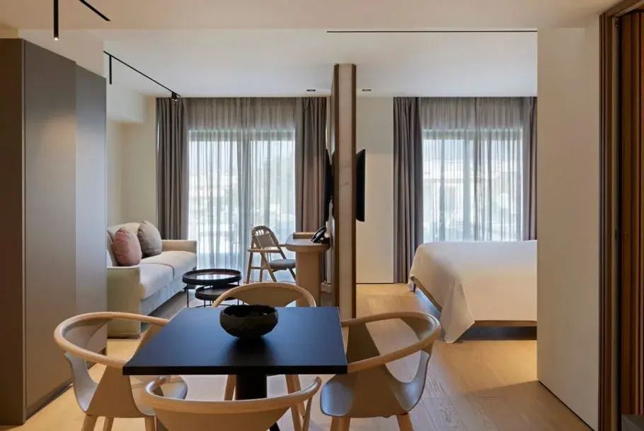 Offener Grundriss mit Wohnbereich, Essecke und großem Fenster in der Kassiope Suite.