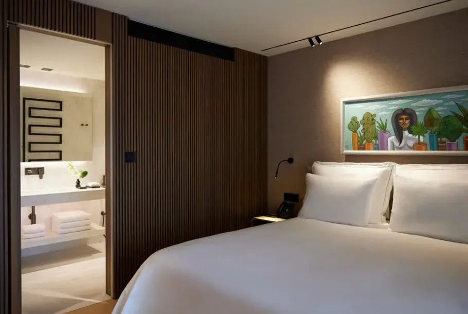 Hotelzimmer mit Doppelbett, Holzvertäfelung und einem modernen Gemälde an der Wand