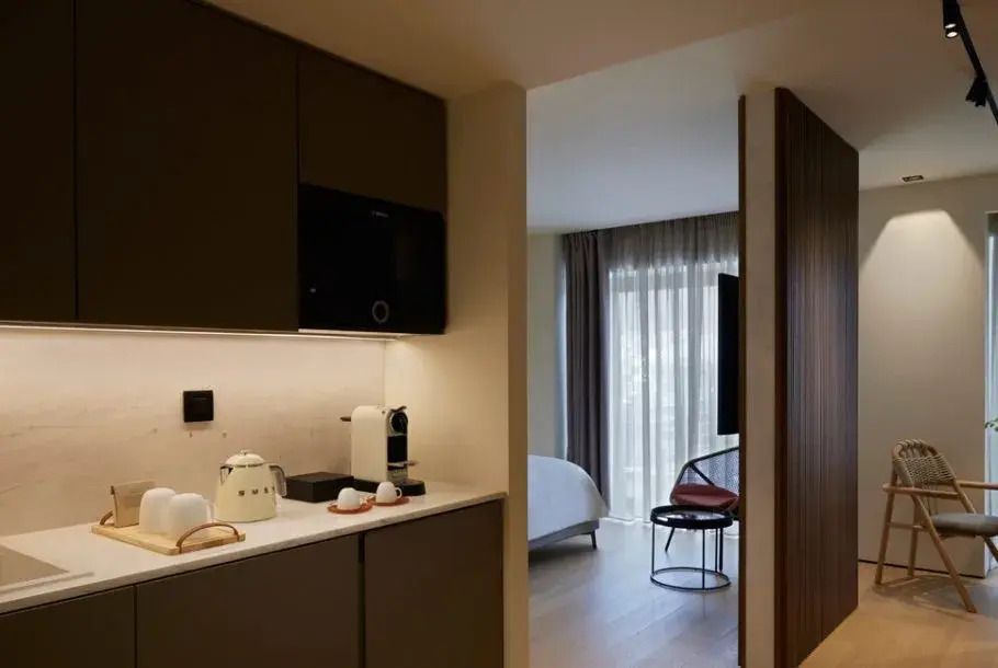 Kleine Hotelküche mit modernen Geräten neben einem Schlafbereich