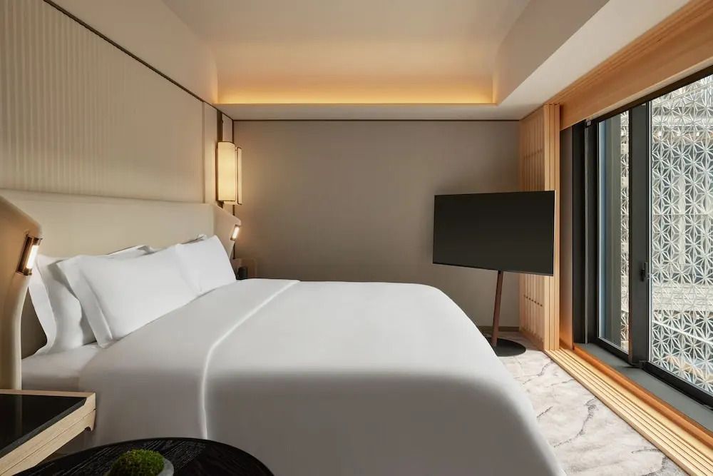 Moderner Schlafbereich mit großem Bett und TV in der Suite