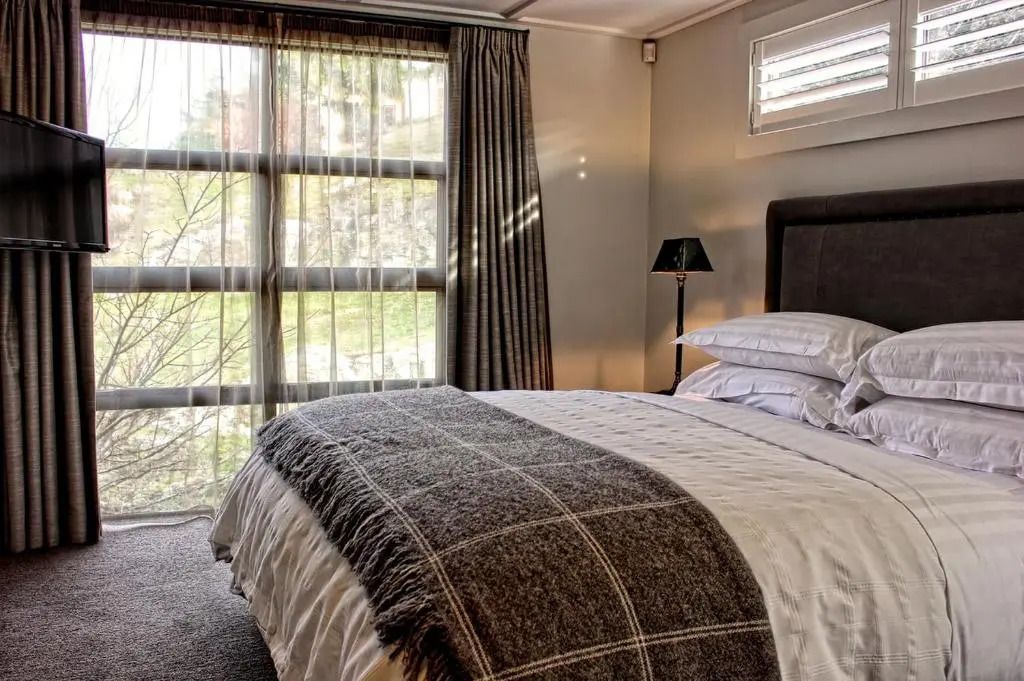 Modernes Schlafzimmer mit großen Fenstern und natürlichem Licht im Deluxe Villa Zimmer.