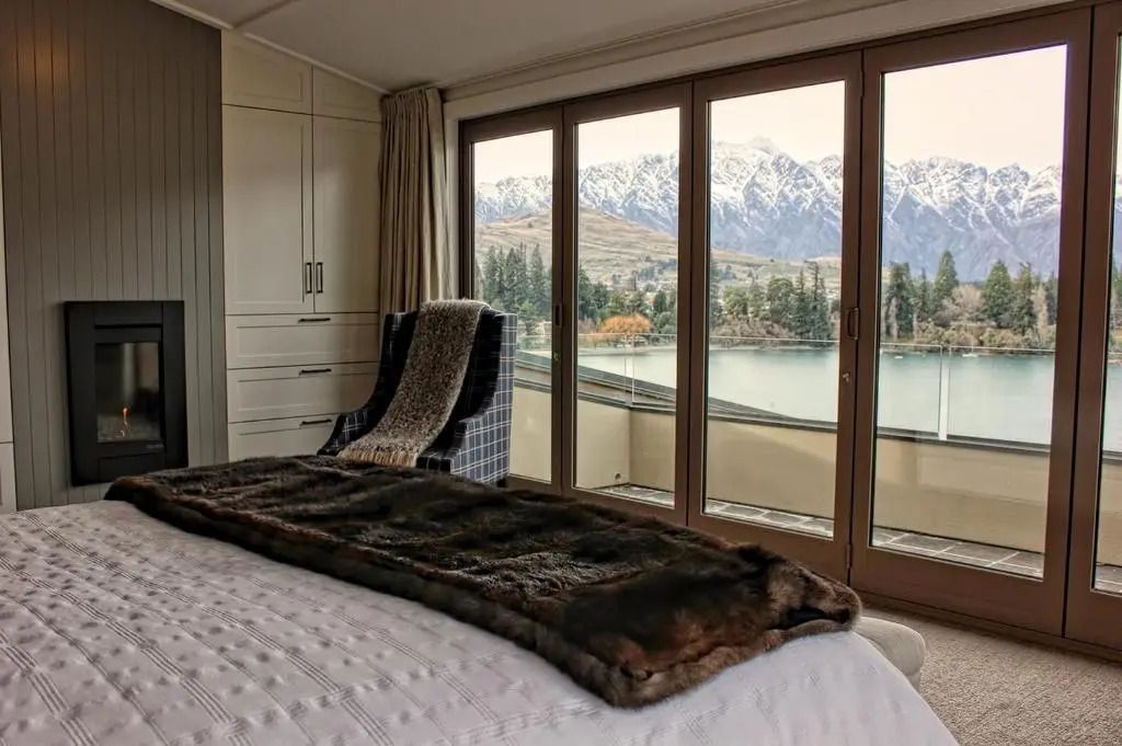Schlafzimmer mit Aussicht auf schneebedeckte Berge und See im Deluxe Villa Zimmer.