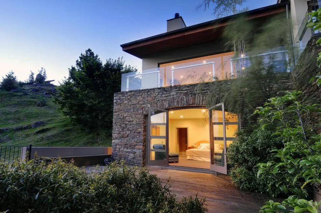 Ansicht der Deluxe Villa mit großzügiger Terrasse und abendlicher Beleuchtung.