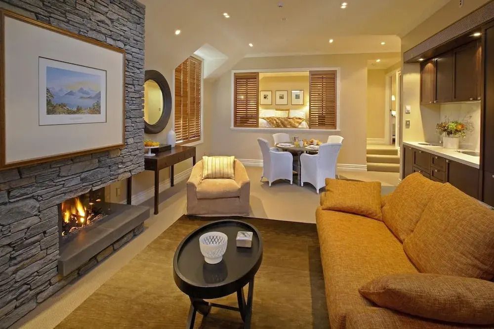 Elegantes Wohnzimmer im Apartment mit Kamin, Sofa und Esstisch im modernen Design