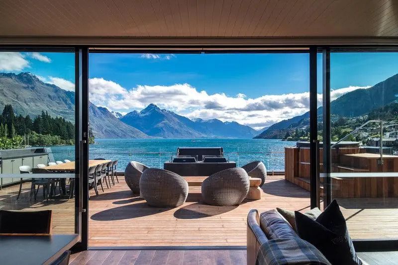 Panoramablick auf See und Berge von einer Terrasse mit stilvollen Möbeln