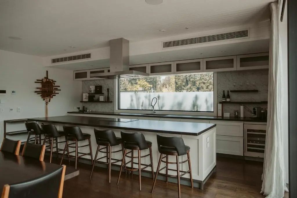 Moderne Küche mit Kochinsel und Barhockern in luxuriösem Ambiente