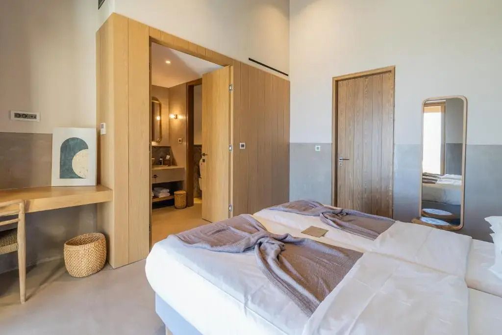 Modernes Schlafzimmer mit zwei Einzelbetten. Zugang zum stilvollen Bad.