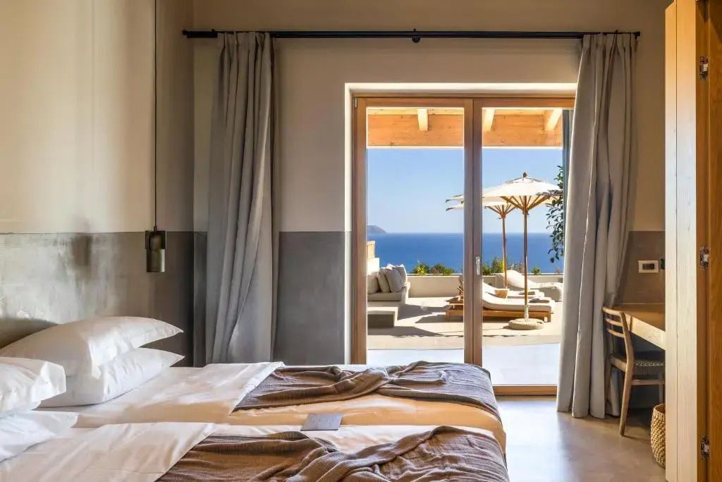 Helles Schlafzimmer mit Zugang zu einer Terrasse und atemberaubendem Meerblick.