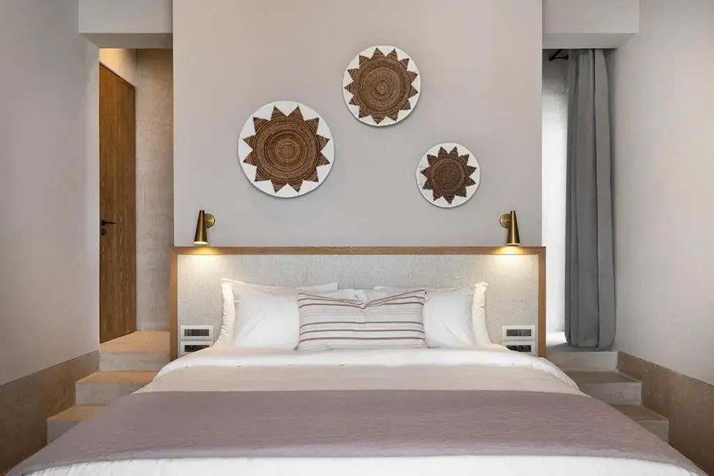 Geschmackvolles Schlafzimmer mit dekorativen Kunstwerken über dem Bett.