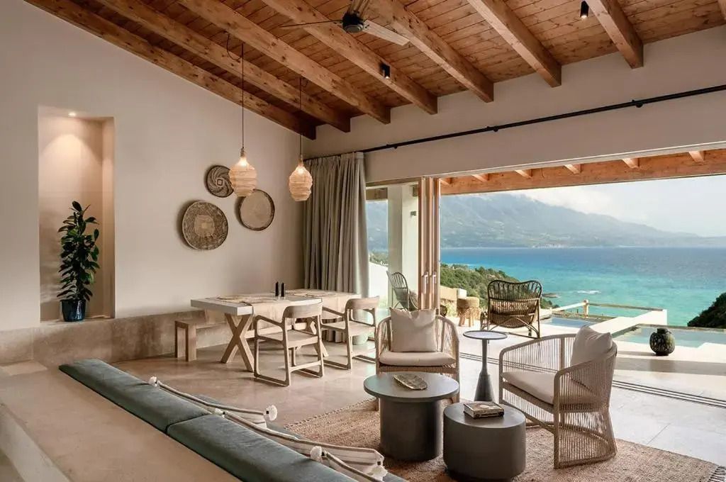 Helles Wohnzimmer mit Blick auf das Meer und elegante Holzbalkendecke
