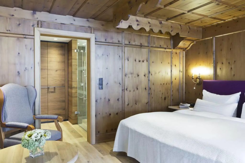 Gemütliches Doppelzimmer mit Holzwänden und Doppelbett
