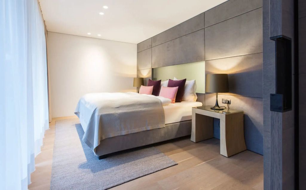 Modern eingerichtetes Schlafzimmer mit Doppelbett und stilvollen Beleuchtungselementen
