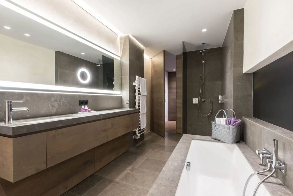 Modernes Badezimmer mit großer Badewanne und beleuchtetem Spiegel