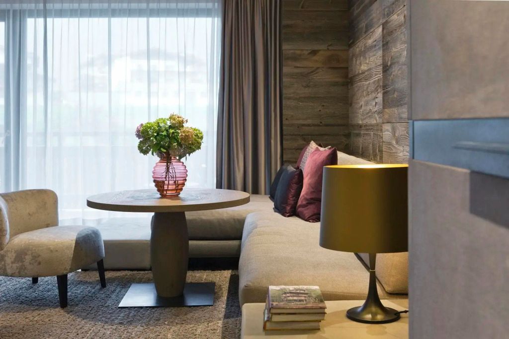 Wohnbereich mit gemütlichem Sofa, Blumen auf dem Tisch und warmer Beleuchtung