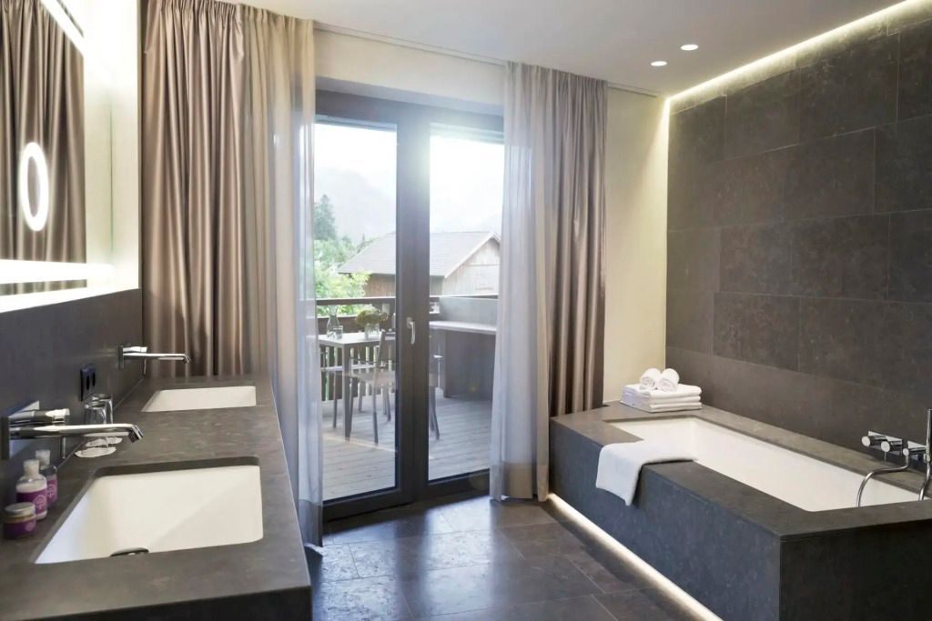 Badezimmer mit stilvoller Badewanne und Balkonzugang in der Prestige Suite