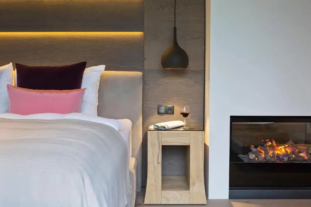 Elegantes Schlafzimmer mit modernem Design, Bett, Beistelltisch und Kamin