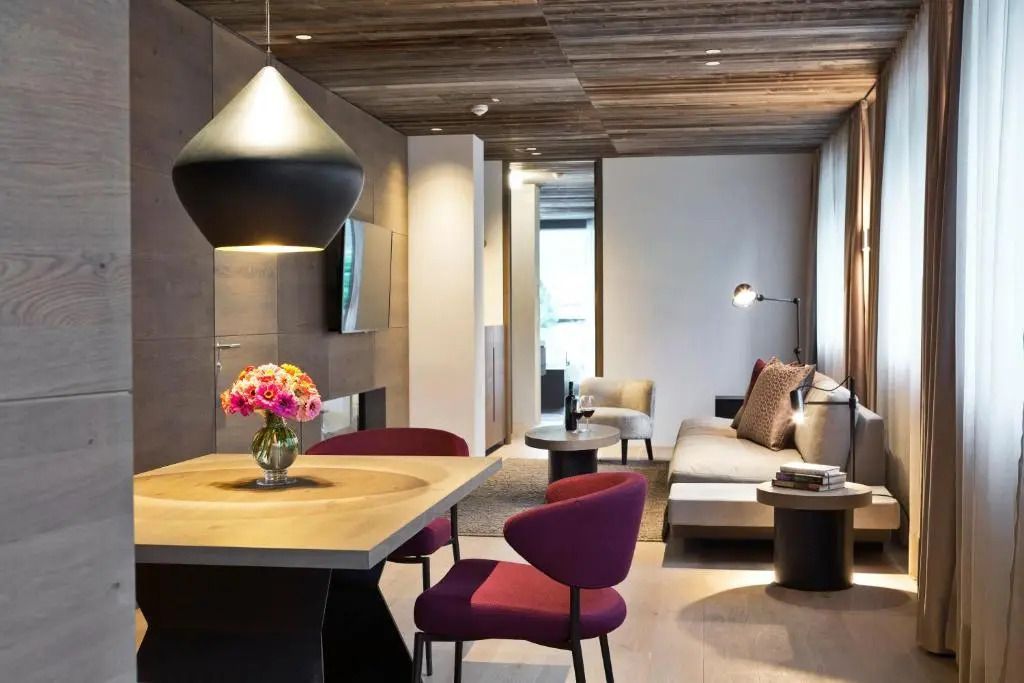 Moderne Suite mit Holzelementen, gemütlicher Sitzecke und stilvollem Esstisch