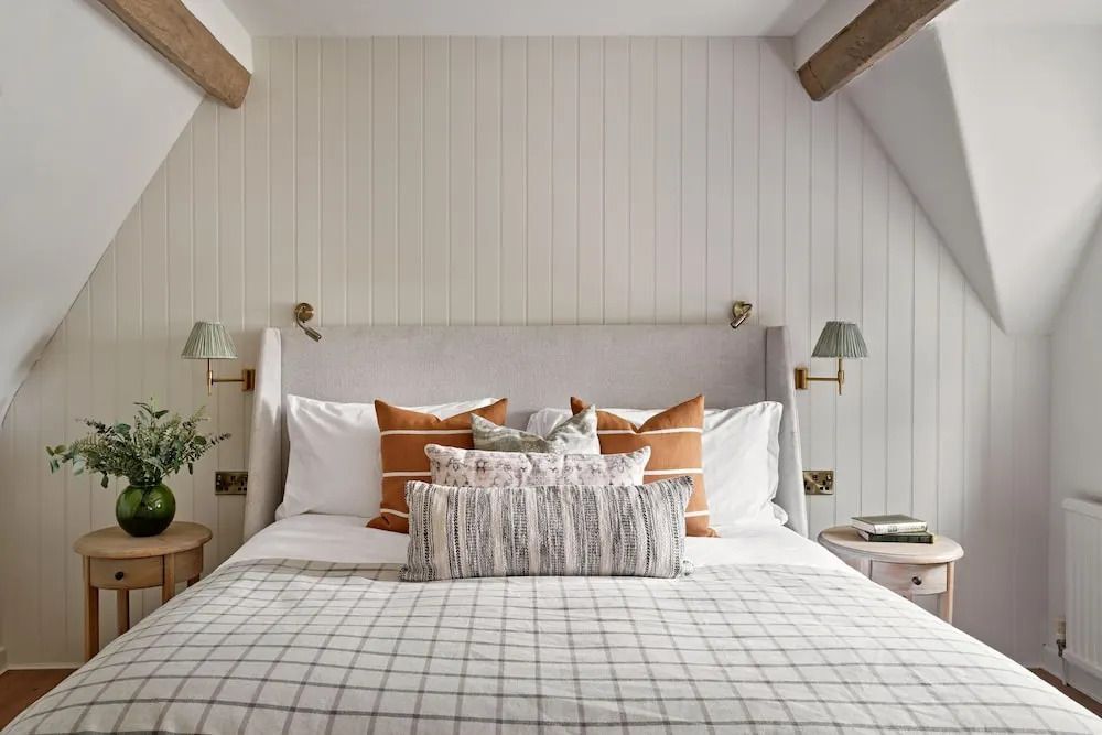 Gemütliches Schlafzimmer mit Holzdeckenbalken und dekorativen Kissen