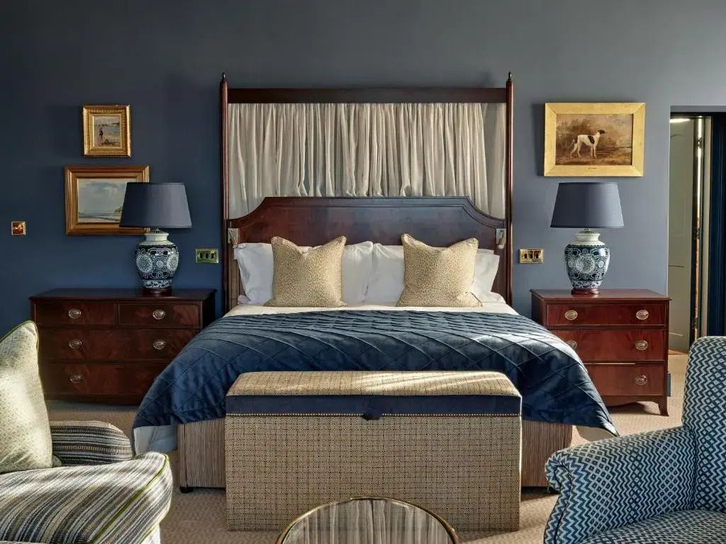Großzügige Suite mit Himmelbett, eleganten Möbeln und blauen Akzenten