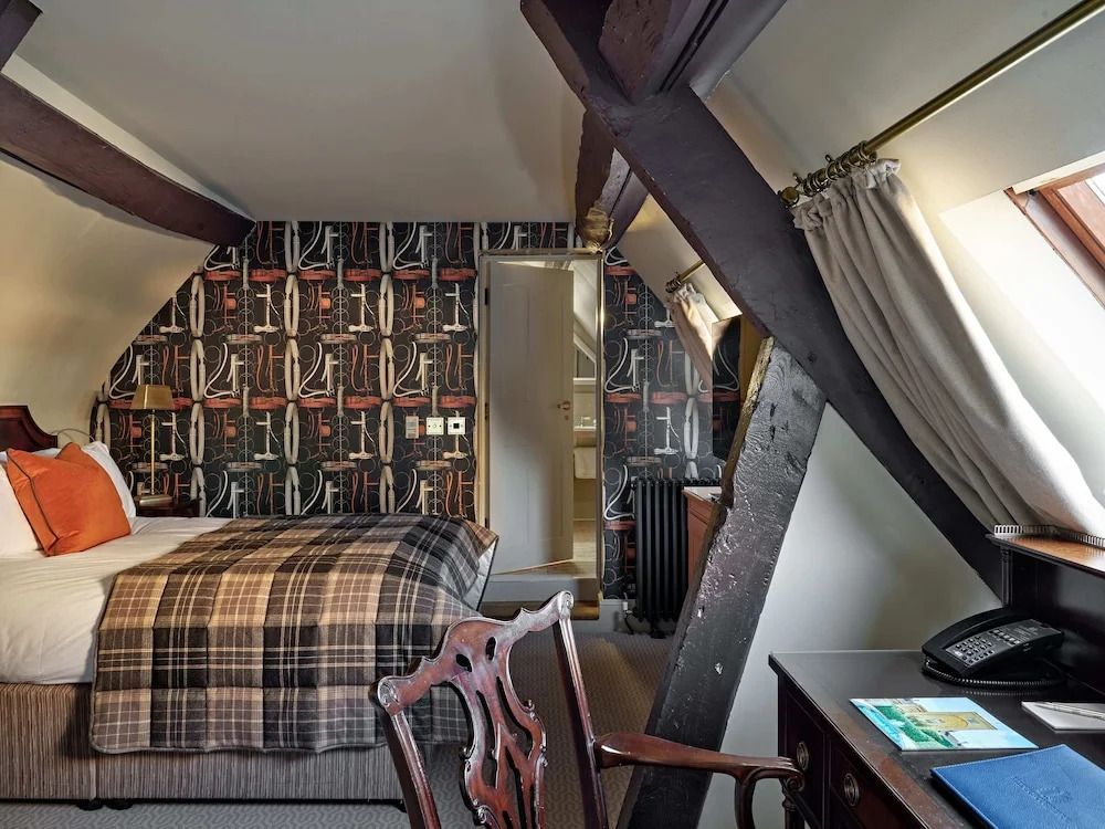 Dachzimmer mit charakteristischen Holzbalken und stilvoller Wandgestaltung