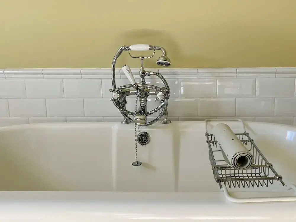 Klassische Badewanne mit nostalgischen Armaturen und weißen Fliesen