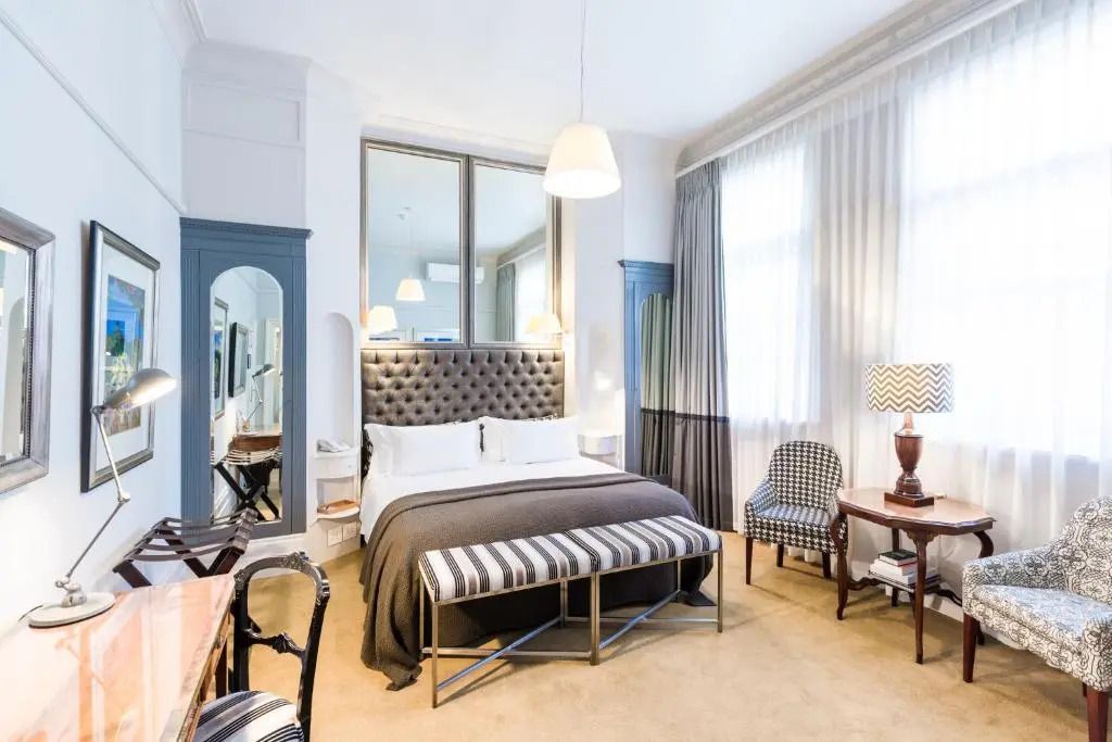 Helles Doppelzimmer mit Polsterbett und gedämpfter Beleuchtung.