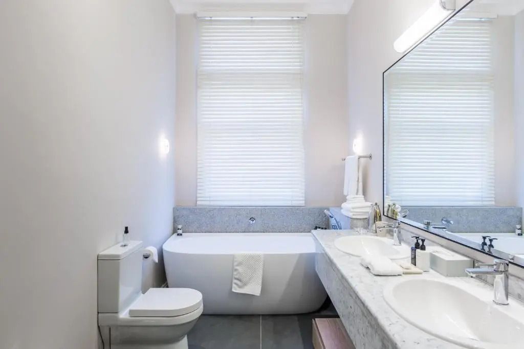 Badezimmer mit Badewanne und Doppelwaschbecken in elegantem Design.