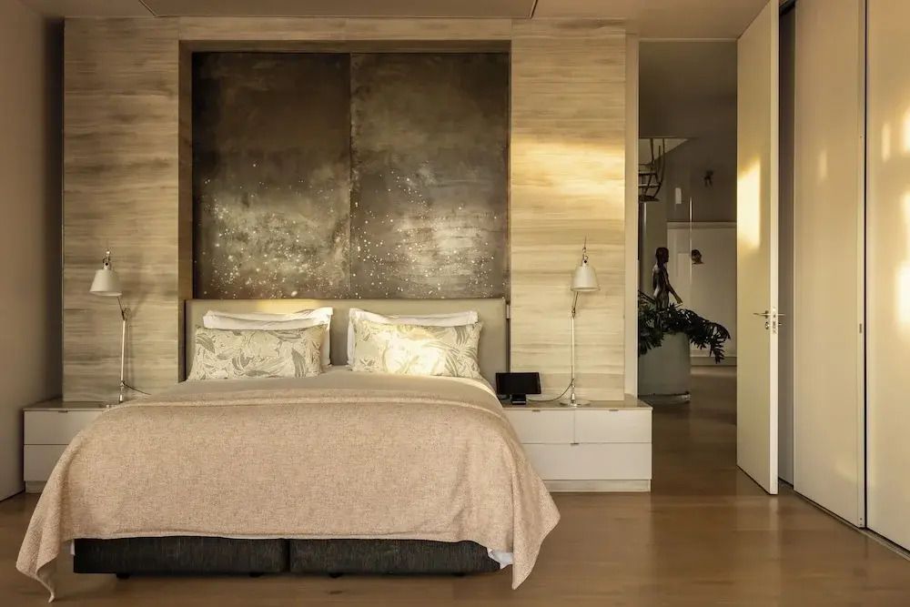Luxuriöses Schlafzimmer mit edler Bettwäsche und dezenter Beleuchtung.