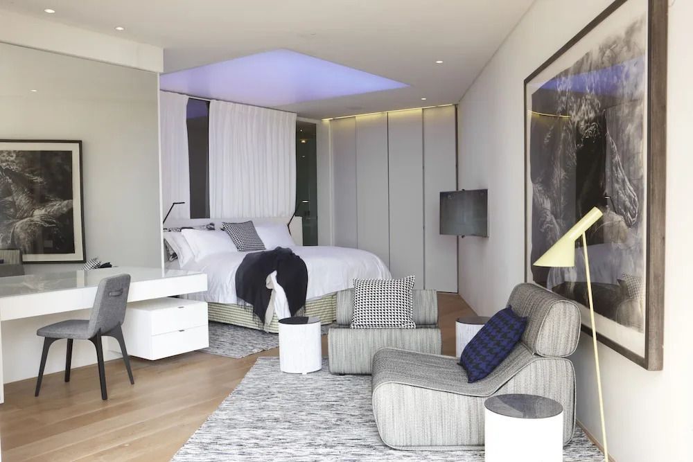 Modern eingerichtetes Zimmer mit Designer-Möbeln und großer Fensterfront.