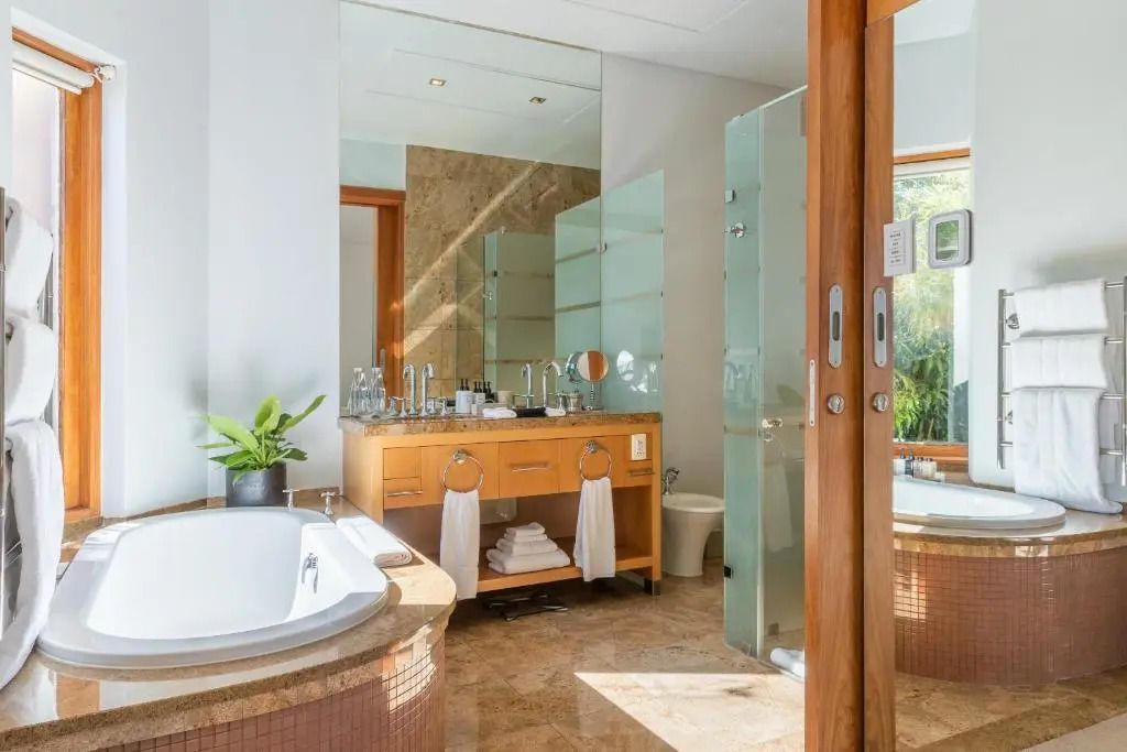 Modernes Badezimmer mit Badewanne und großer Spiegelwand im Ellerman House