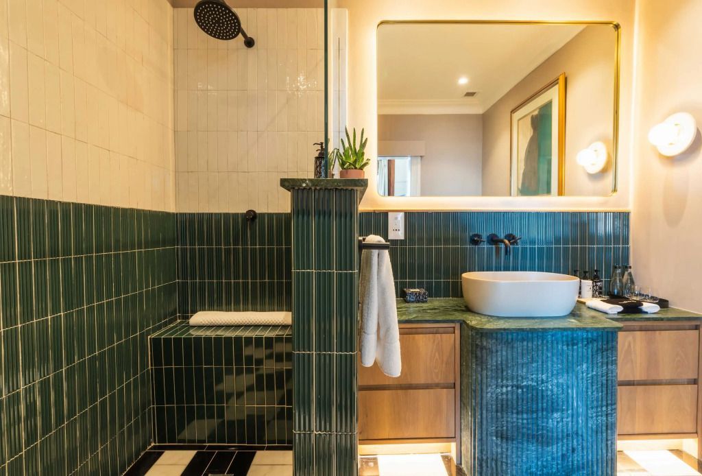 Modernes Badezimmer mit stilvollen grünen Fliesen und elegantem Waschbecken.
