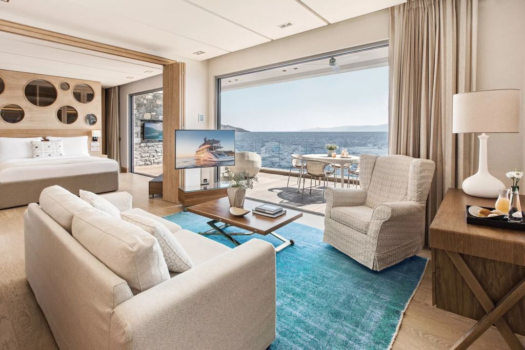Helles Wohnzimmer einer Suite mit Blick aufs Meer und einladender Terrasse.