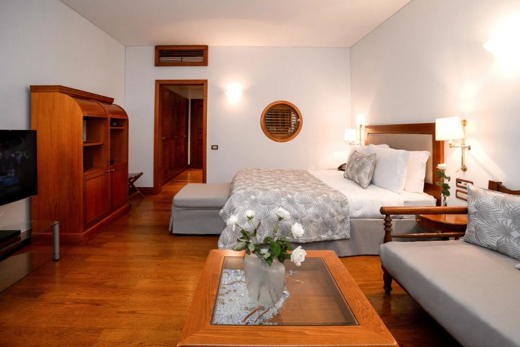 Deluxe Zimmer mit Holzmöbeln und Doppelbett sowie elegantem Dekor.