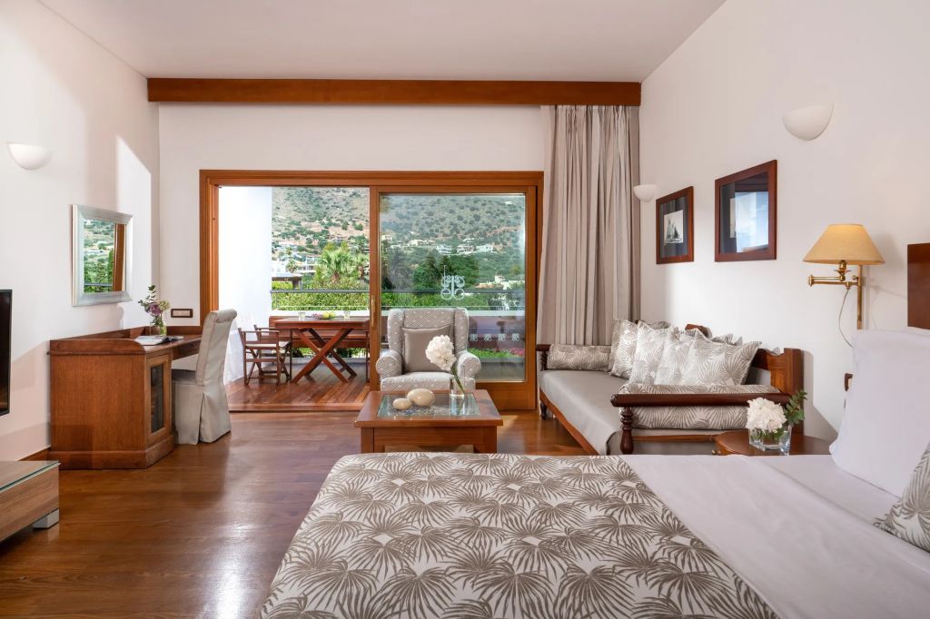 Helles Deluxe Zimmer mit Sitzgelegenheiten und Terrasse mit Gartenblick.
