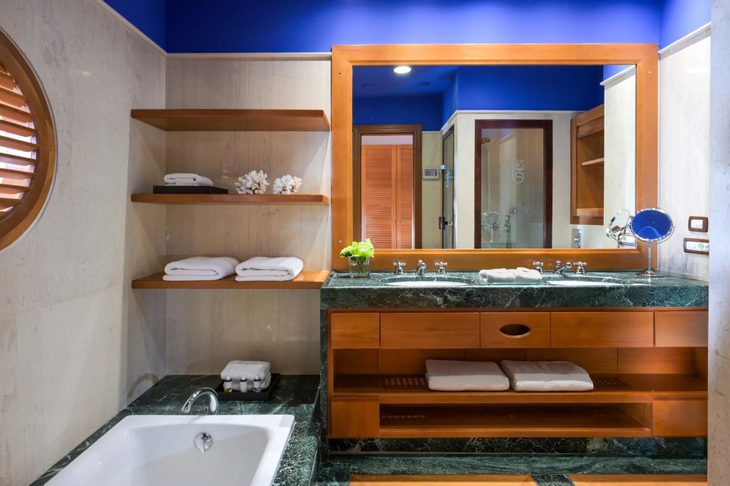 Elegantes Badezimmer mit Marmordekor und großen Spiegeln.