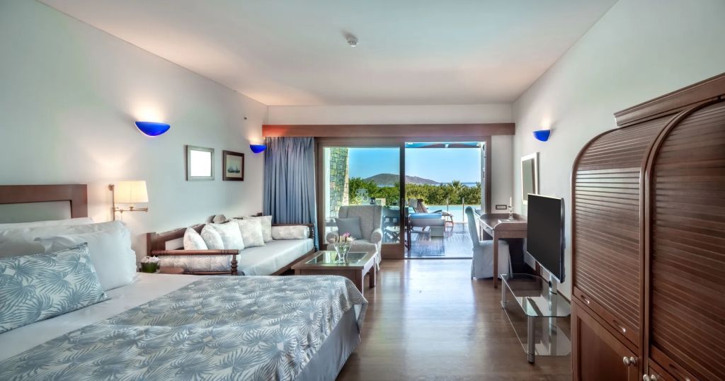 Stilvolles Zimmer mit Fernseher und Zugang zu Terrasse mit Poolblick.
