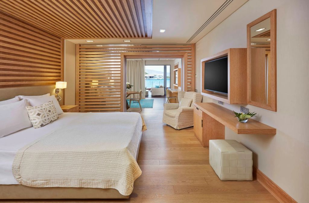 Modernes Schlafzimmer mit Holzverkleidung und Ausblick auf Pool