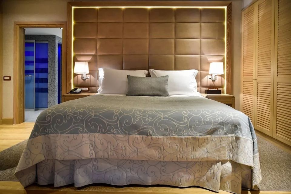 Elegantes Schlafzimmer in der Villa mit luxuriösem Bett, flankiert von Lampen.