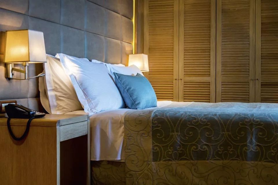 Gemütliches Bett in einem stilvollen, warm beleuchteten Raum.