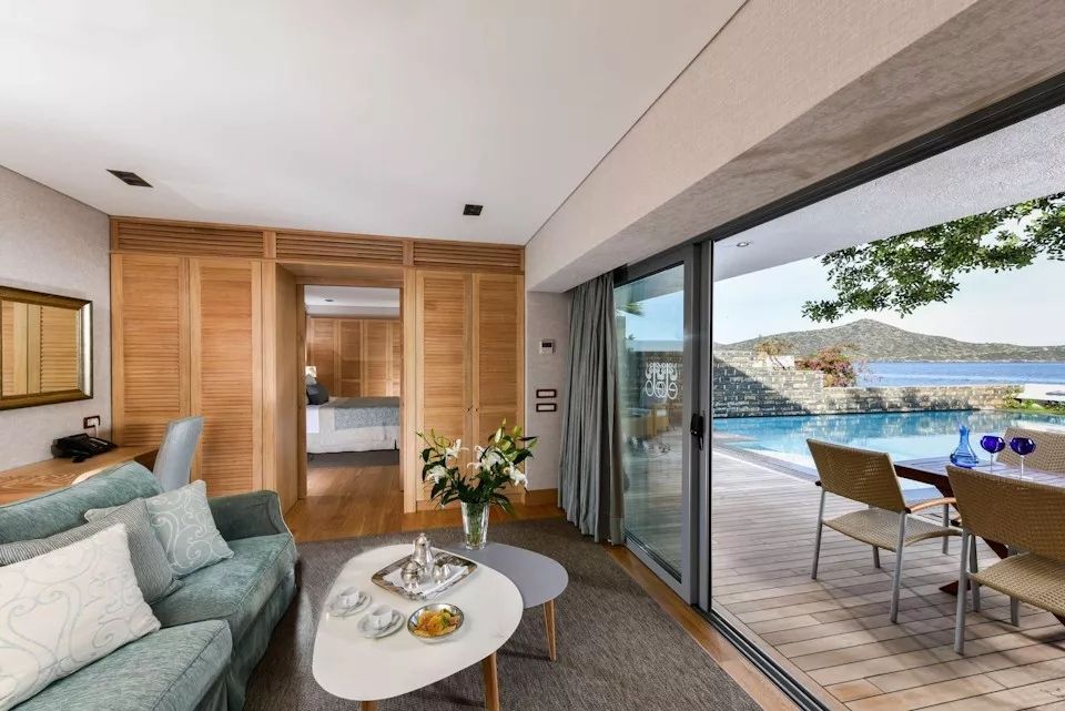 Wohnbereich einer Villa mit direktem Zugang zum Pool und Bergblick.