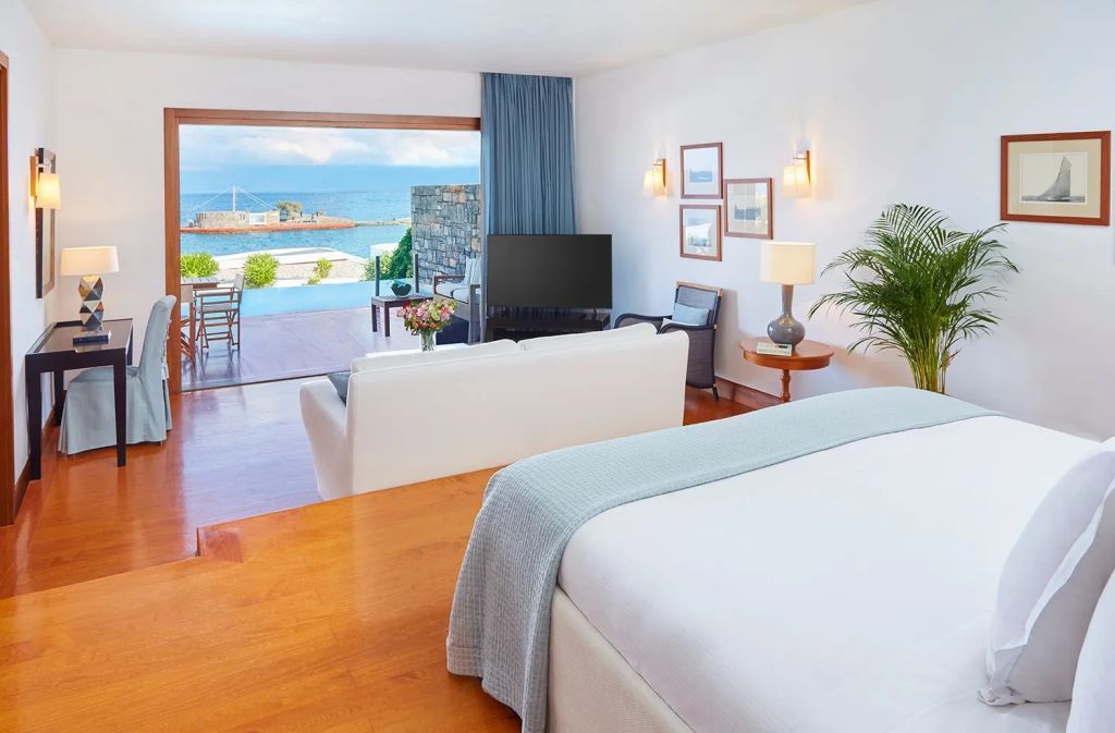 Elegantes Schlafzimmer mit weißem Sofa und Poolblick auf das Meer