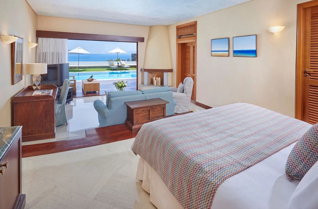 Gemütliches Schlafzimmer mit Lounge und direktem Zugang zum Pool mit Meerblick