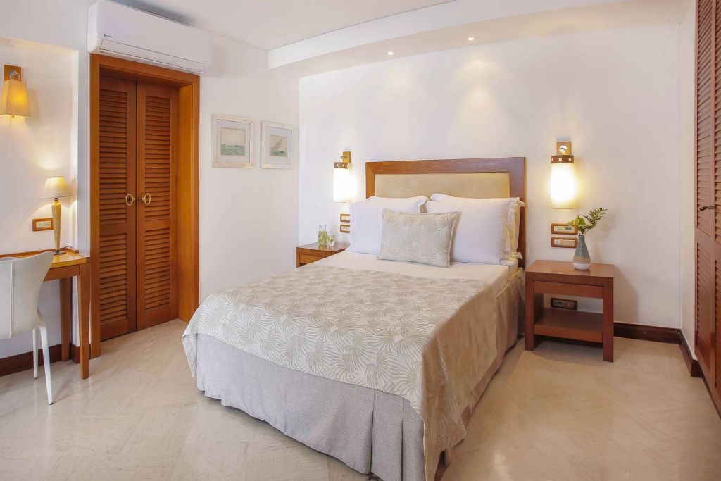 Gemütliches Schlafzimmer in einem Bungalow mit Meerblick. Doppelbett und warme Beleuchtung.