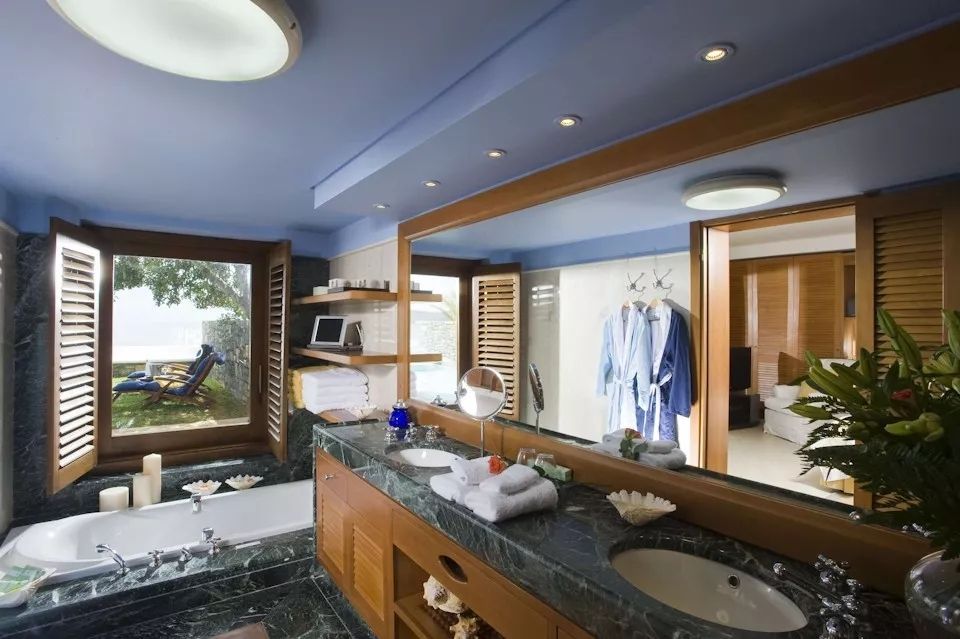 Modernes Badezimmer mit großer Spiegelfläche und Blick ins Grüne. Doppelwaschbecken.