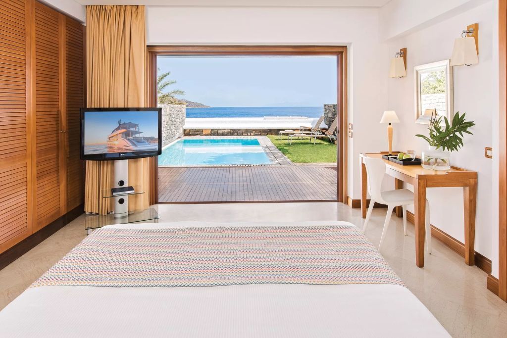 Bungalow-Zimmer mit Blick auf den privaten Pool und das Meer durch große Glasfront