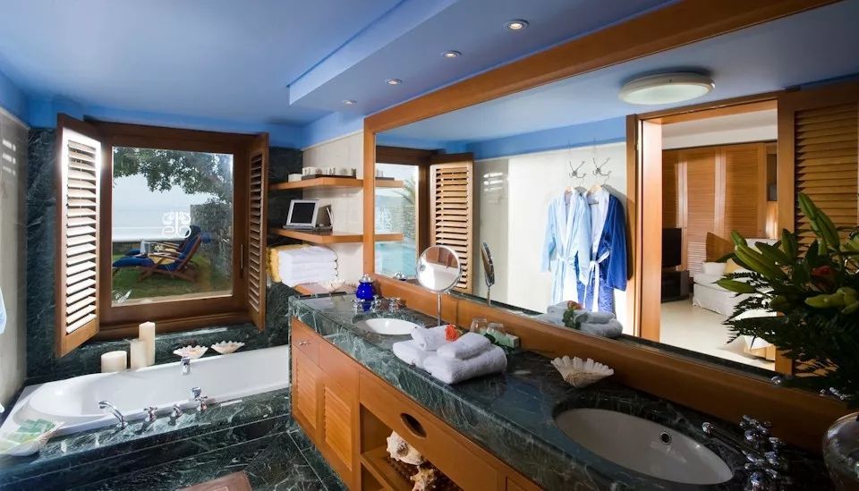 Luxuriöses Badezimmer mit Marmordetails und Ausblick auf die Natur