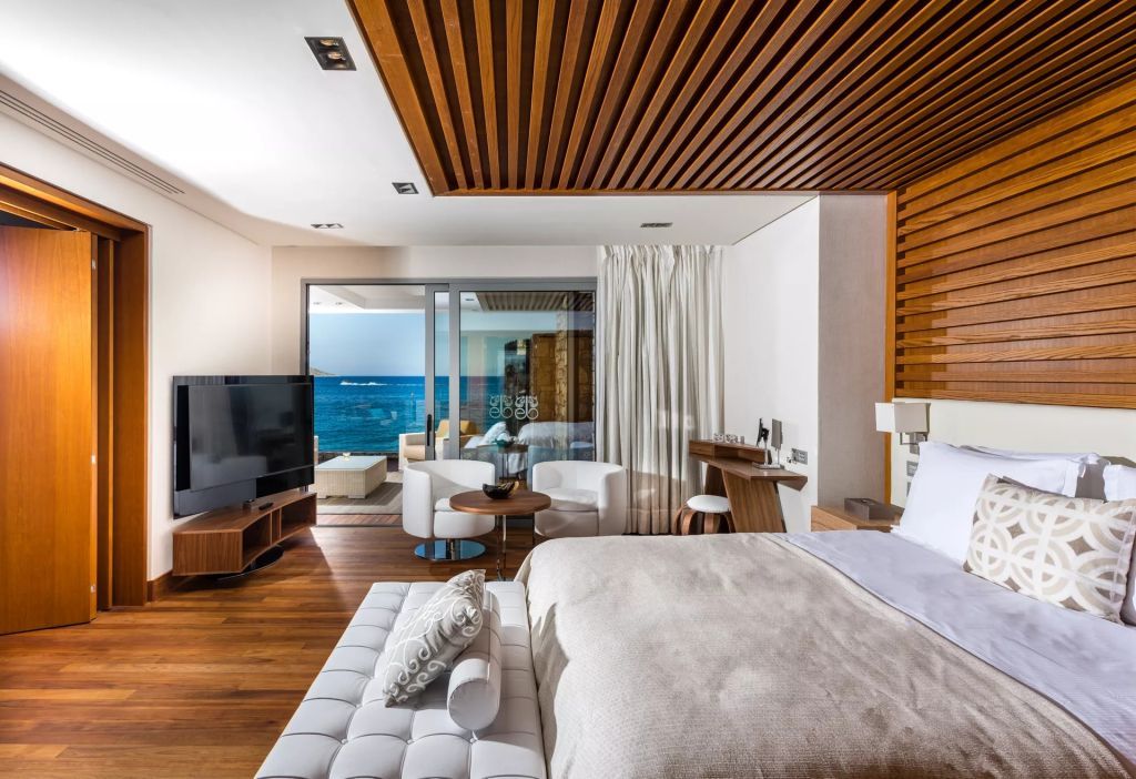 Luxuriöses Schlafzimmer mit Holzdecke, Meerblick und moderner Einrichtung